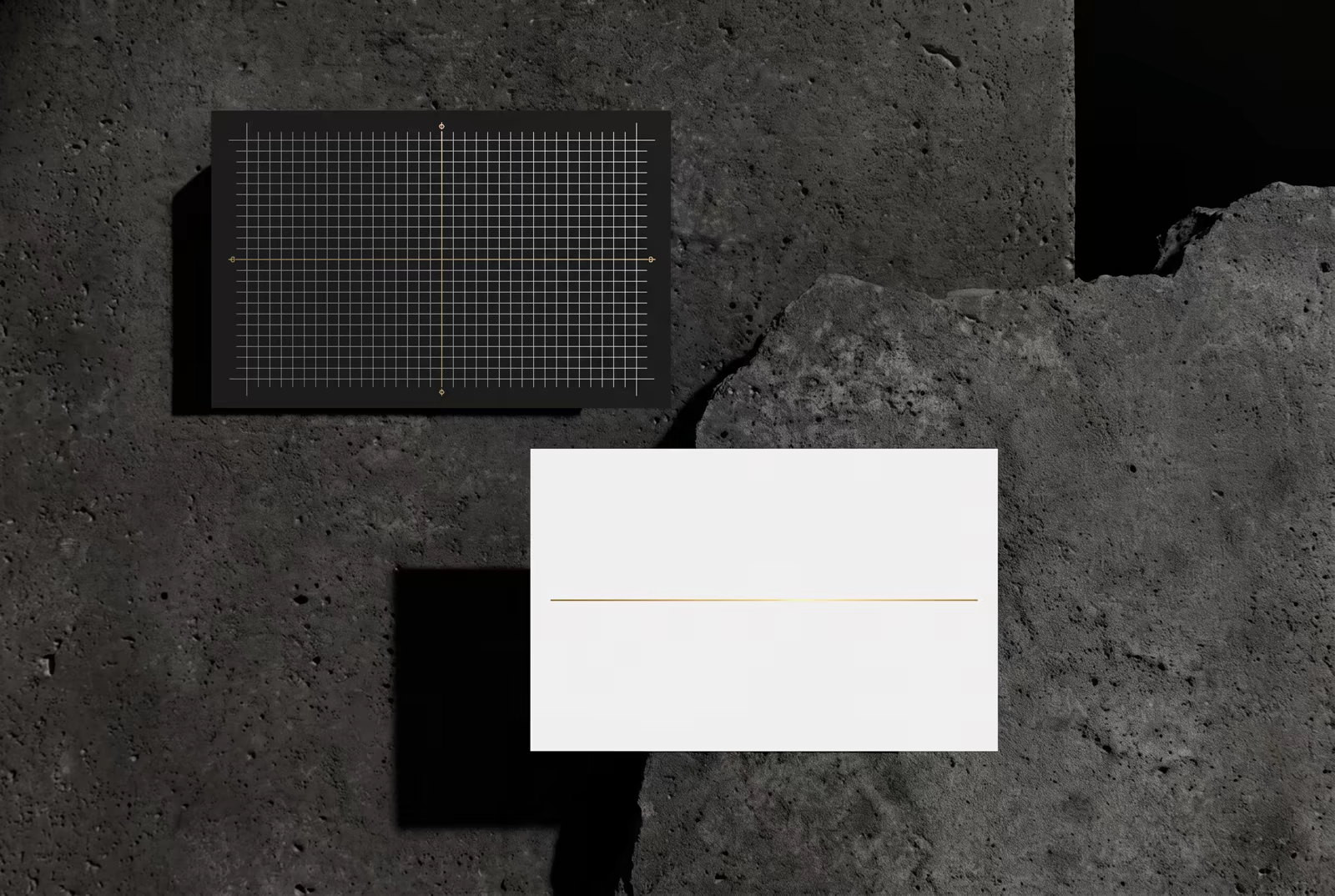 Black and white strategy cards with fine gold grid lines on textured stone