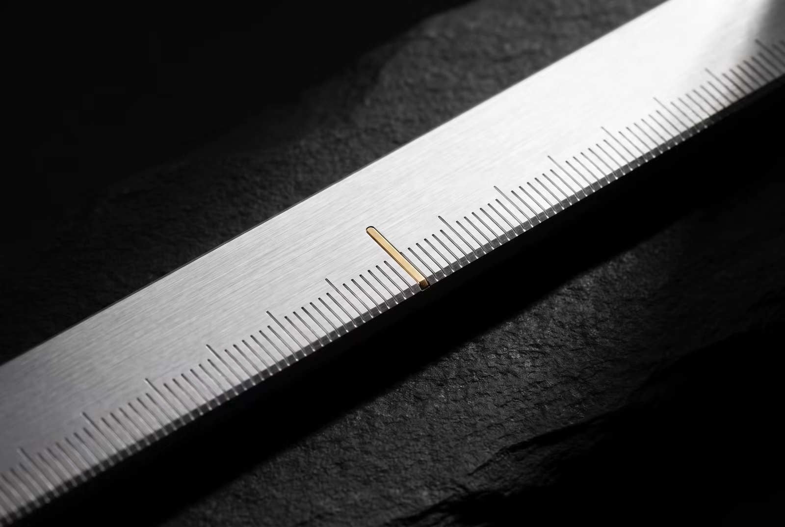 Precision metal ruler with a gold marker representing AI visibility measurement